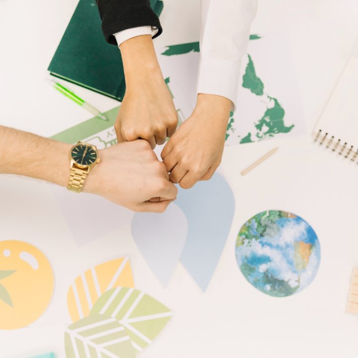 group-businesspeople-fist-bumping-desk